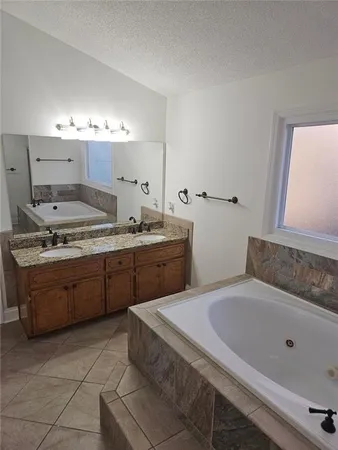 a spacious bathroom with a granite countertop sink and a mirror