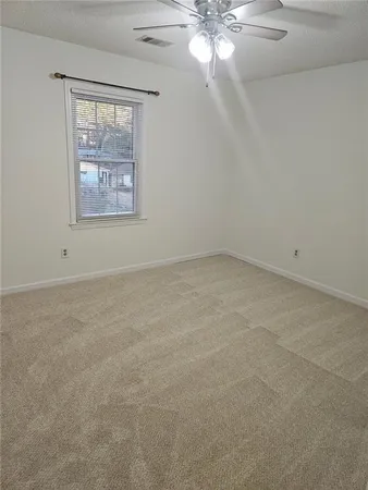 an empty room with a window and a fan
