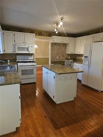 a kitchen with stainless steel appliances granite countertop a stove a sink and a refrigerator