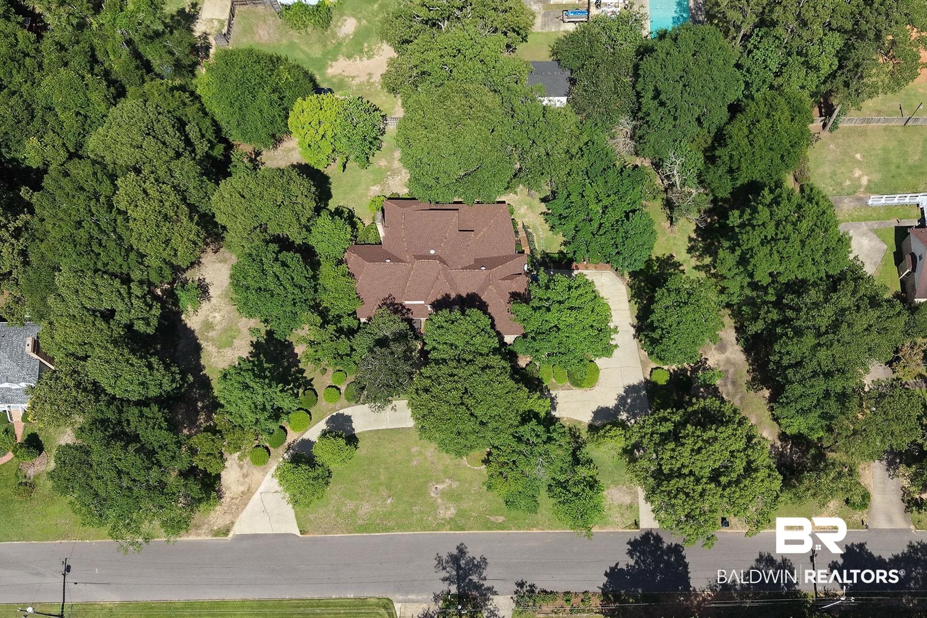 329 Norwood Road Monroeville, AL 36460 - Photo 48 of 49 Expansive lot featuring a multi-gabled roofline, mature tree canopy, concrete driveway, and established landscaping