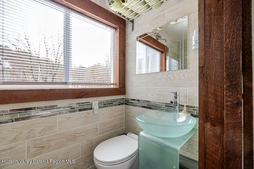 91 Miller Road Canaan, NY 12029 - Photo 18 of 29 a bathroom with a granite countertop toilet a sink and a mirror