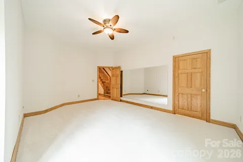 an empty room with closet and fan