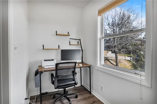 a view of a workspace with furniture and a window