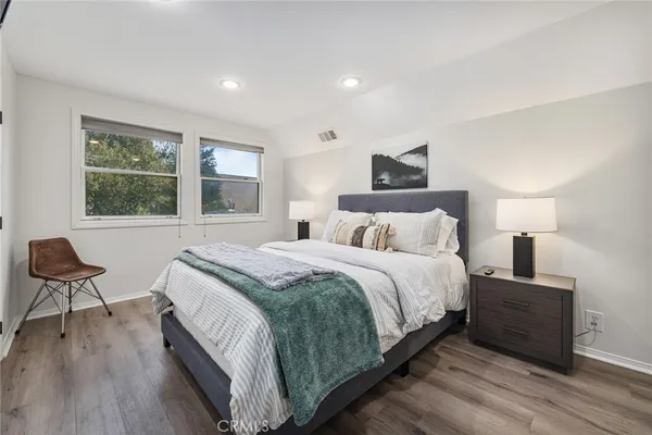 a bedroom with a bed and wooden floor