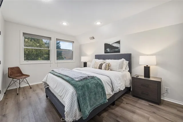 a bedroom with a bed and wooden floor
