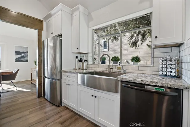 a kitchen with stainless steel appliances granite countertop a sink a stove and a refrigerator