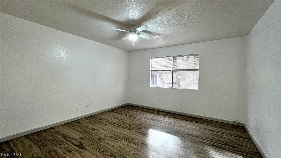 6750 Del Rey Avenue, Unit 123 Las Vegas, NV 89146 - Photo 3 of 21 A well-lit bedroom features rich wood flooring and a refreshing ceiling fan for comfort.