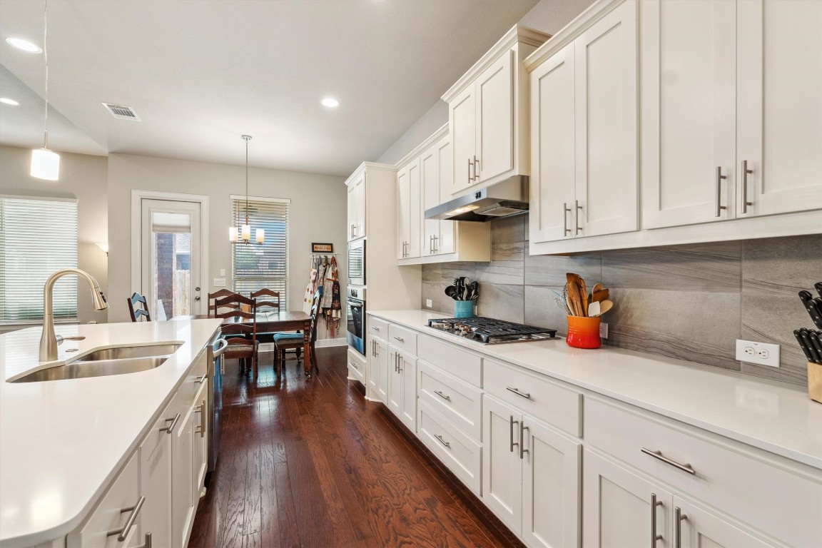 1005 Hezekiah Lane Leander, TX 78641 - Photo 14 of 36 a kitchen with white cabinets sink and stove