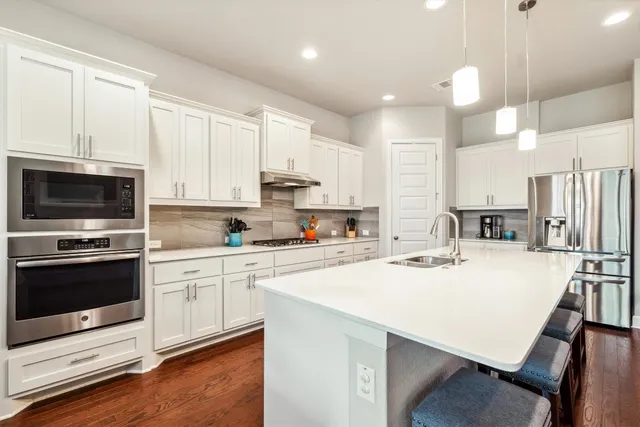 a kitchen with stainless steel appliances a stove a sink a microwave and cabinets