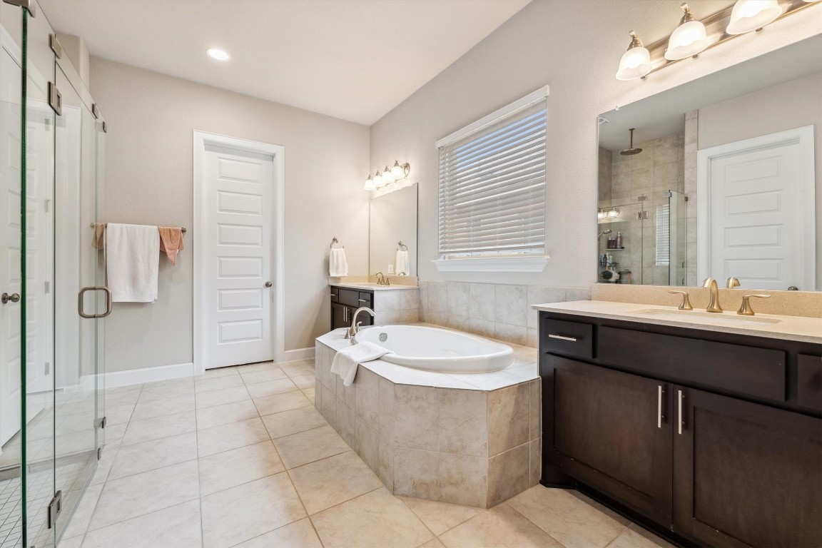 1005 Hezekiah Lane Leander, TX 78641 - Photo 20 of 36 a bathroom with a bathtub sink mirror and shower