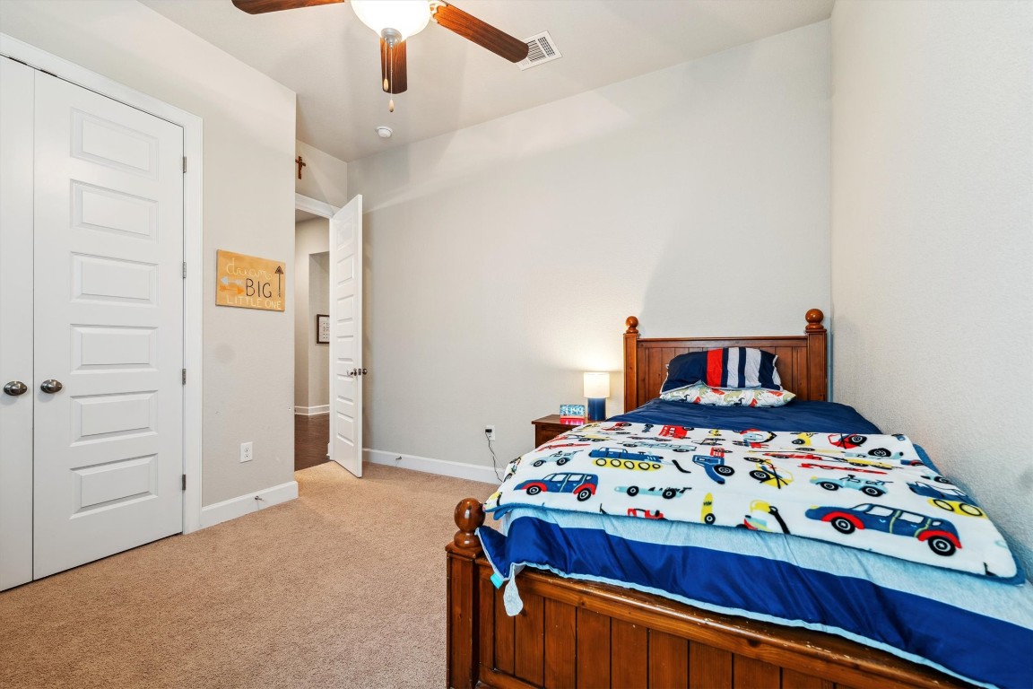 1005 Hezekiah Lane Leander, TX 78641 - Photo 31 of 36 a bedroom with a bed and a chandelier