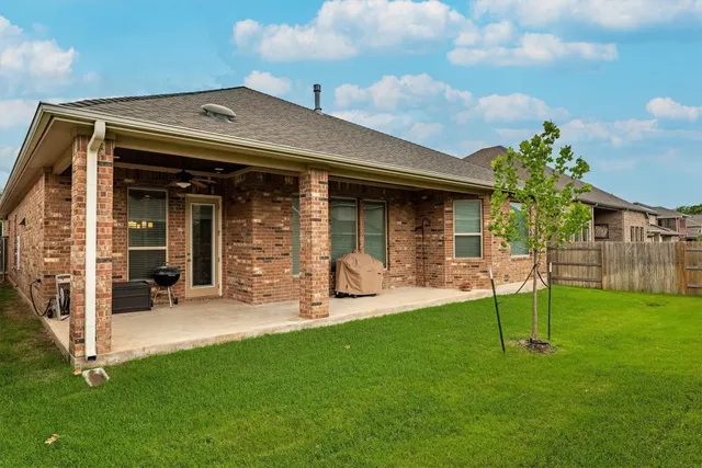 a view of a chair and table in backyard of the house