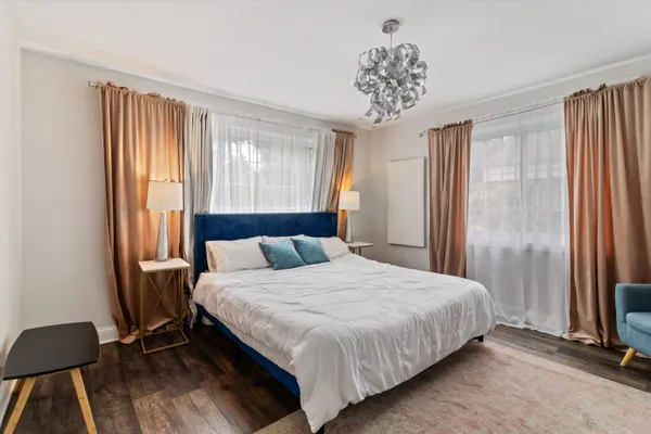 a bedroom with a bed table and a window