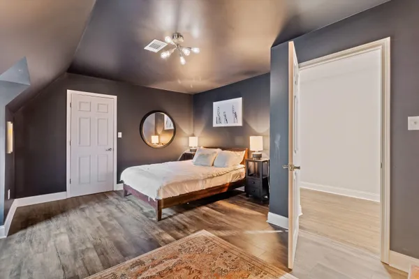 a bed sitting in a bedroom next to a lamp