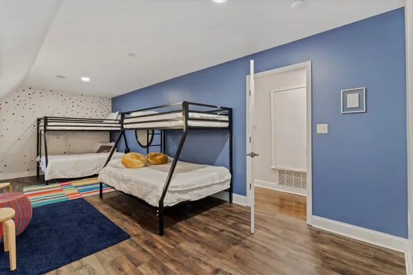 a bedroom with a bed and wooden floor