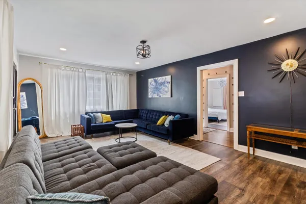 a living room with furniture a rug and a lamp