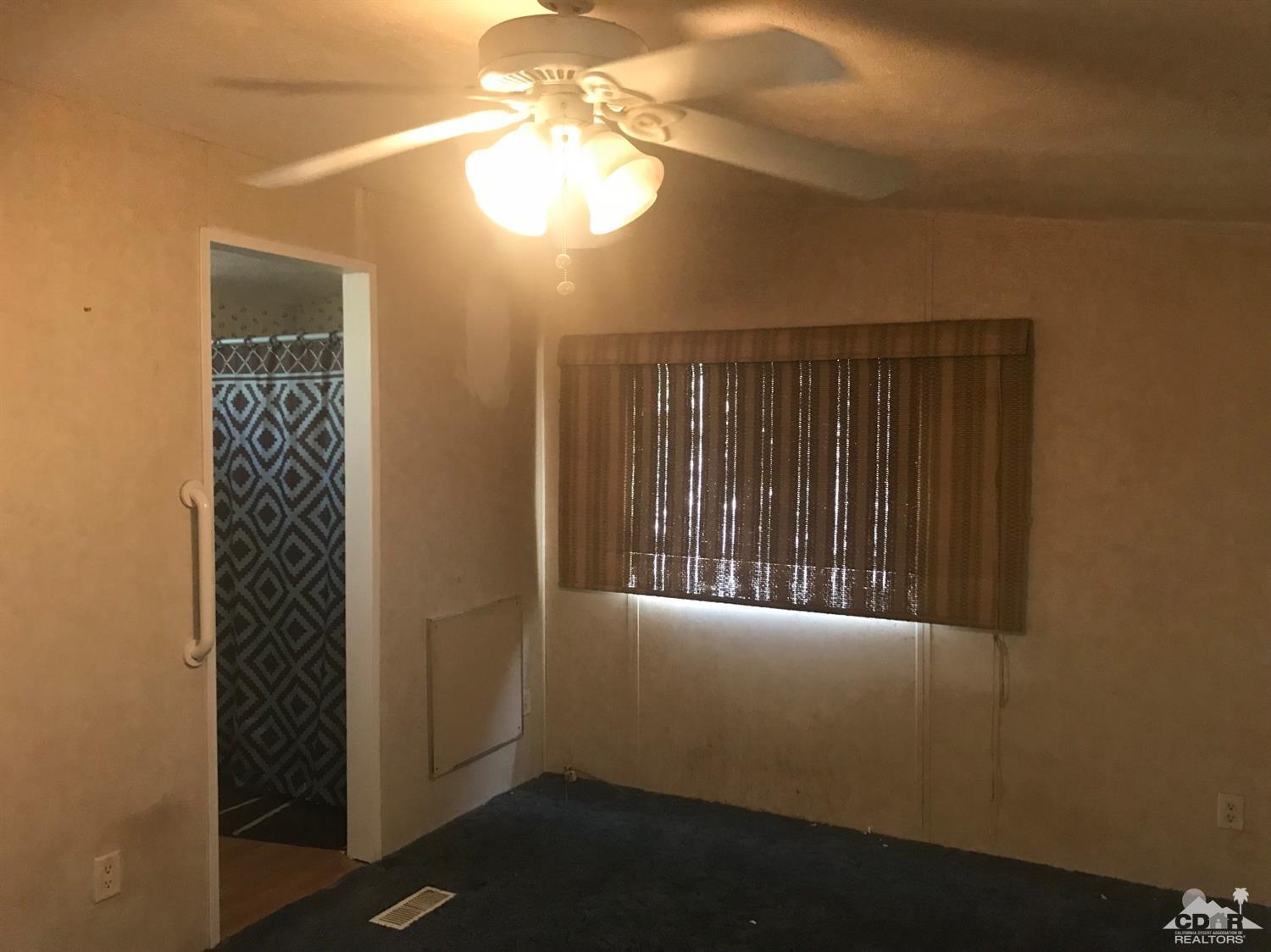 15774 Country View Road Whitewater, CA 92282 - Photo 9 of 16 en empty room with window chandelier fan and windows