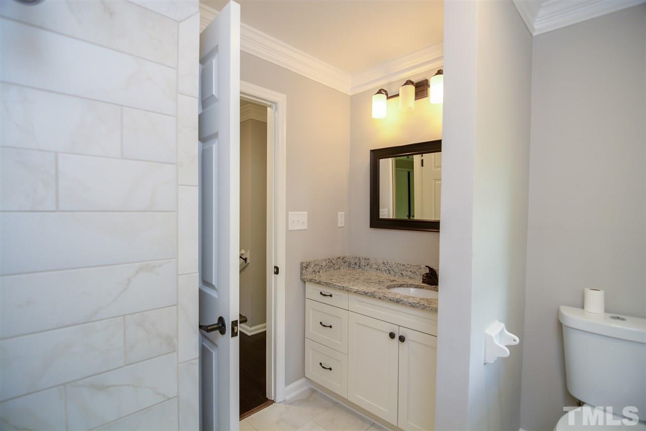 131 Lin Tilley Road Durham, NC 27712 - Photo 23 of 25 a en suite bathroom with a granite countertop sink and a mirror