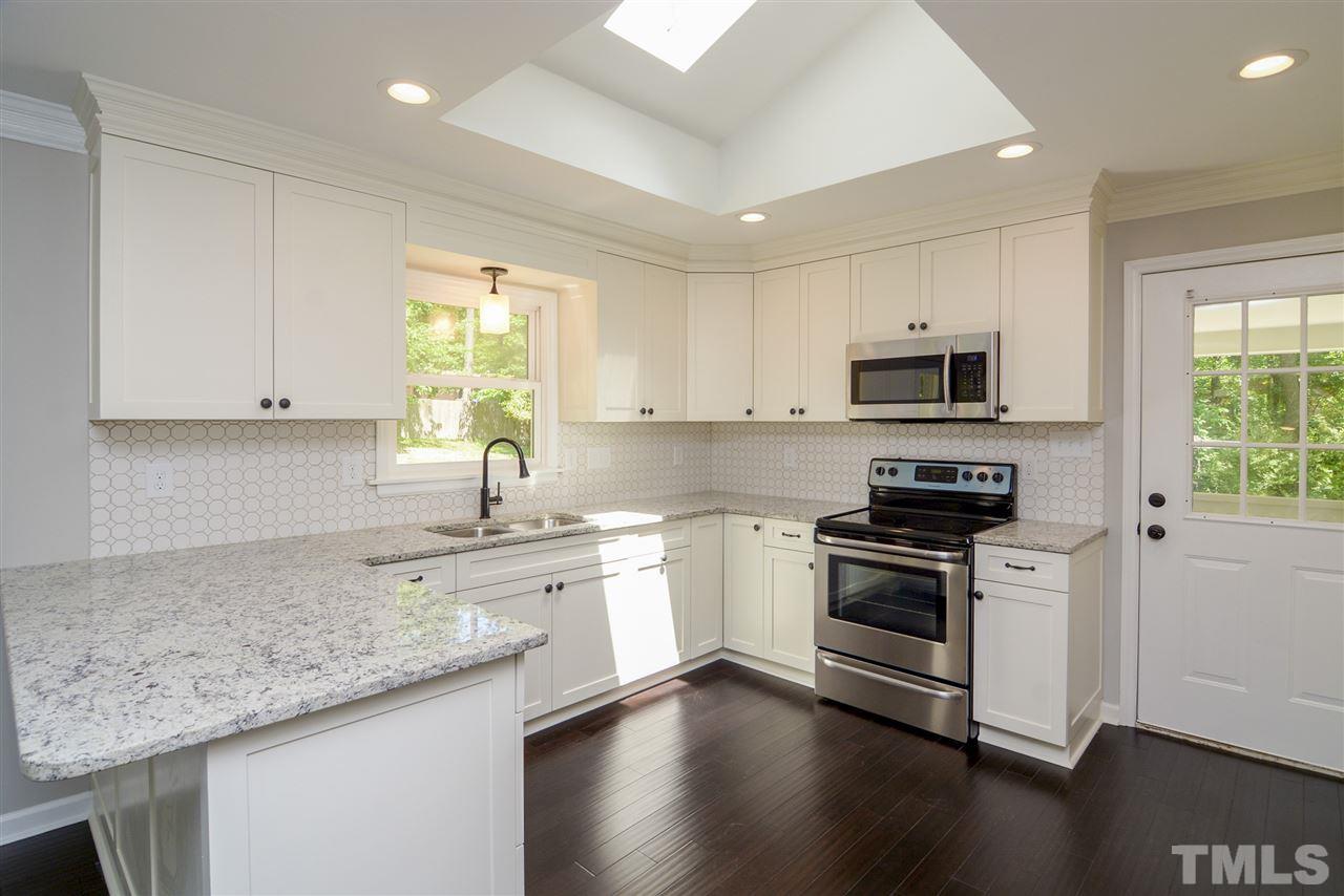 131 Lin Tilley Road Durham, NC 27712 - Photo 9 of 25 a kitchen with a sink stove top oven and cabinets