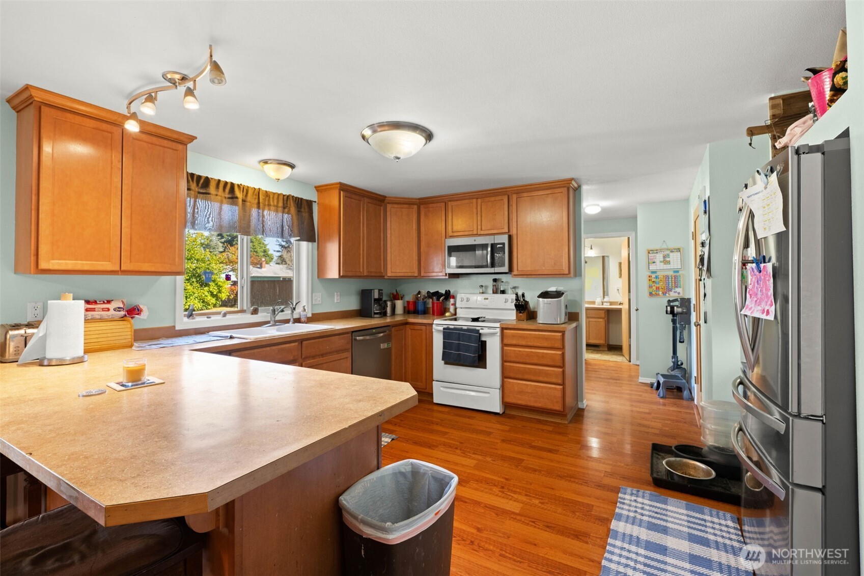 1420 Dundee Drive Cosmopolis, WA 98537 - Photo 8 of 40 a large kitchen with a table chairs wooden cabinets and appliances