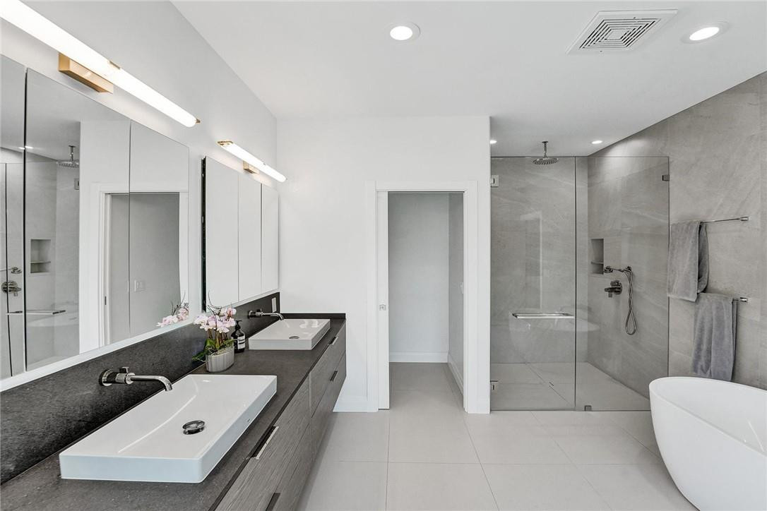 9 Tahoe Lane Sea Ranch Lakes, FL 33308 - Photo 41 of 54 a bathroom with a double vanity sink toilet and shower