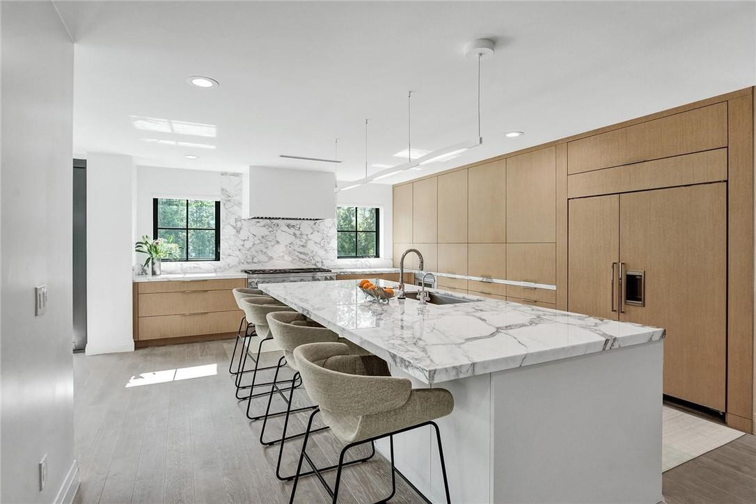 9 Tahoe Lane Sea Ranch Lakes, FL 33308 - Photo 6 of 54 a kitchen with stainless steel appliances granite countertop a sink a stove a refrigerator and white cabinets with wooden floor