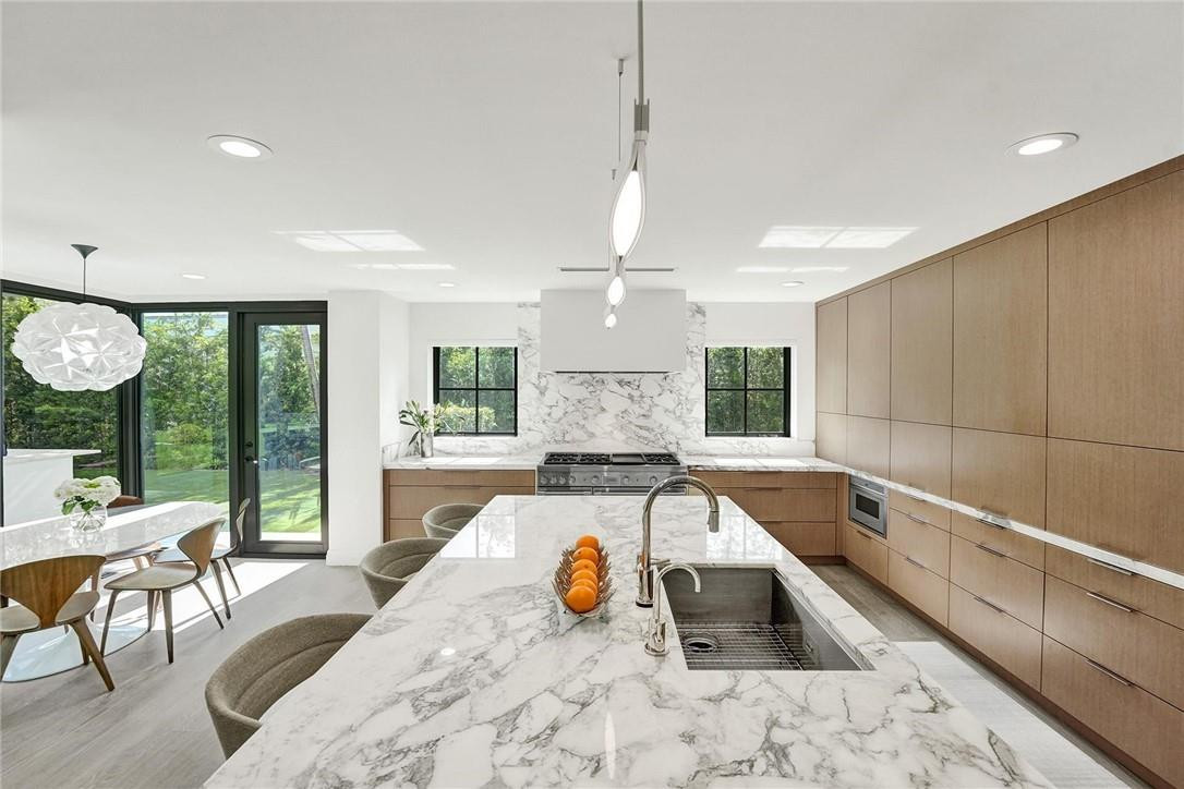 9 Tahoe Lane Sea Ranch Lakes, FL 33308 - Photo 9 of 54 a large kitchen with kitchen island a large window and stainless steel appliances