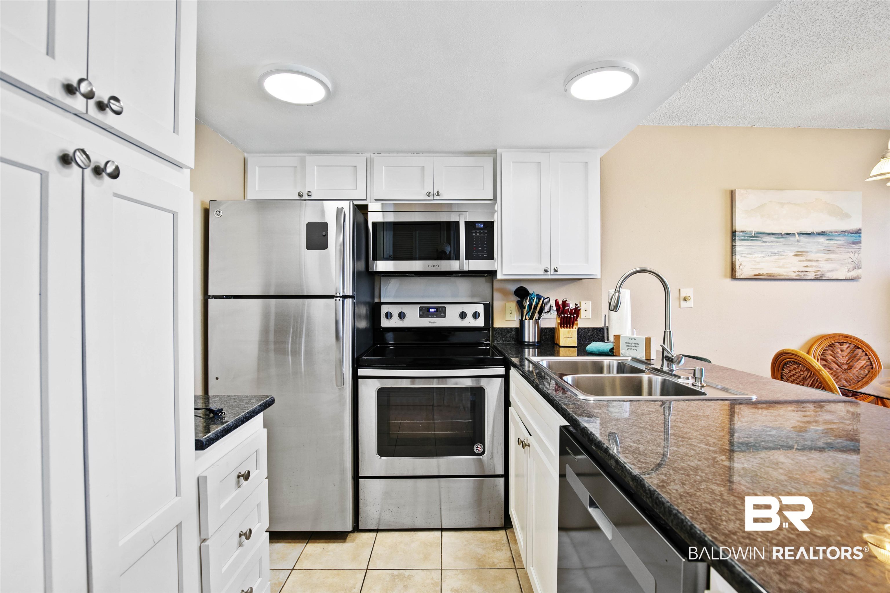 645 Plantation Road, Unit 6606 Gulf Shores, AL 36542 - Photo 12 of 60 Kitchen featuring stainless steel appliances, white cabinetry, and granite countertops