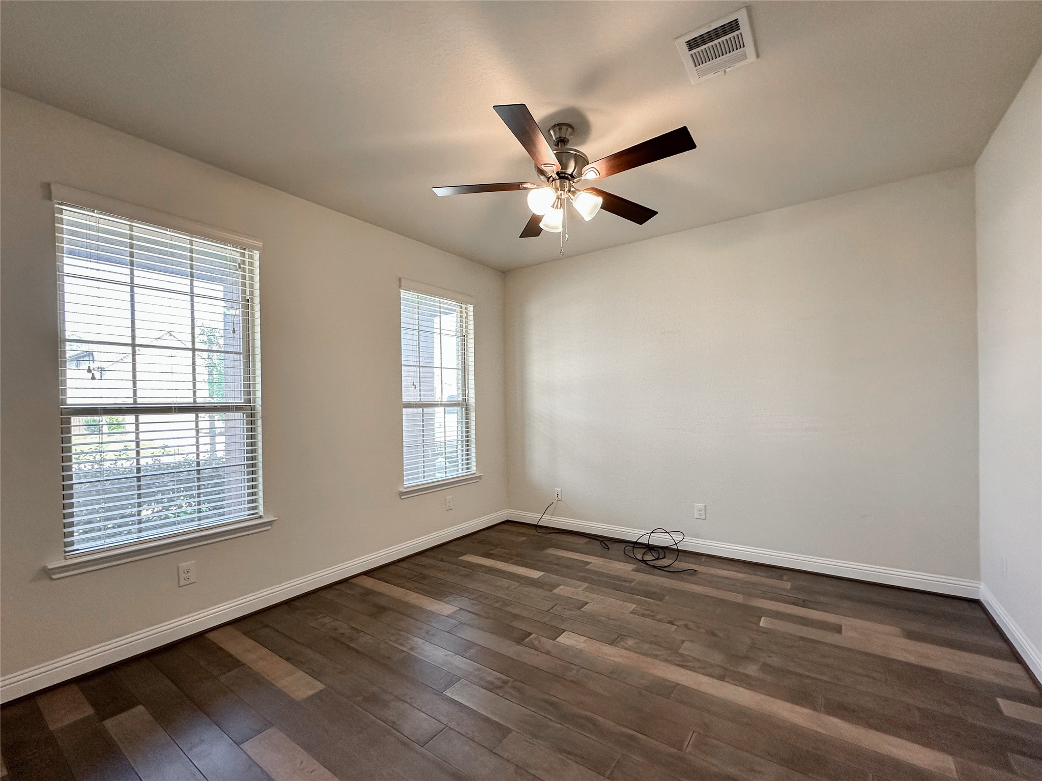 6715 Chicoma Street Spring, TX 77379 - Photo 5 of 20 an empty room with wooden floor fan and windows