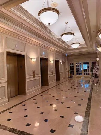 a view of a hallway with dining space and chandelier