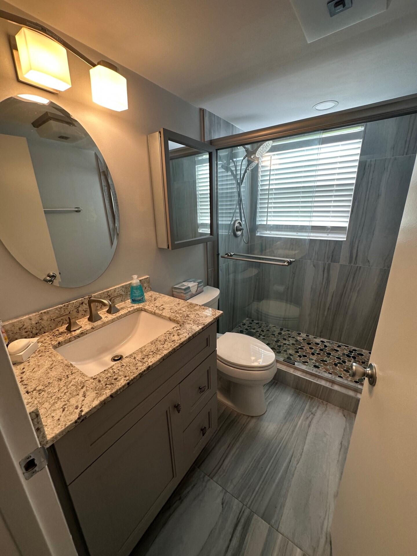 340 Mansfield Drive Boca Raton, FL 33434 - Photo 17 of 23 a bathroom with a granite countertop sink toilet a mirror and shower