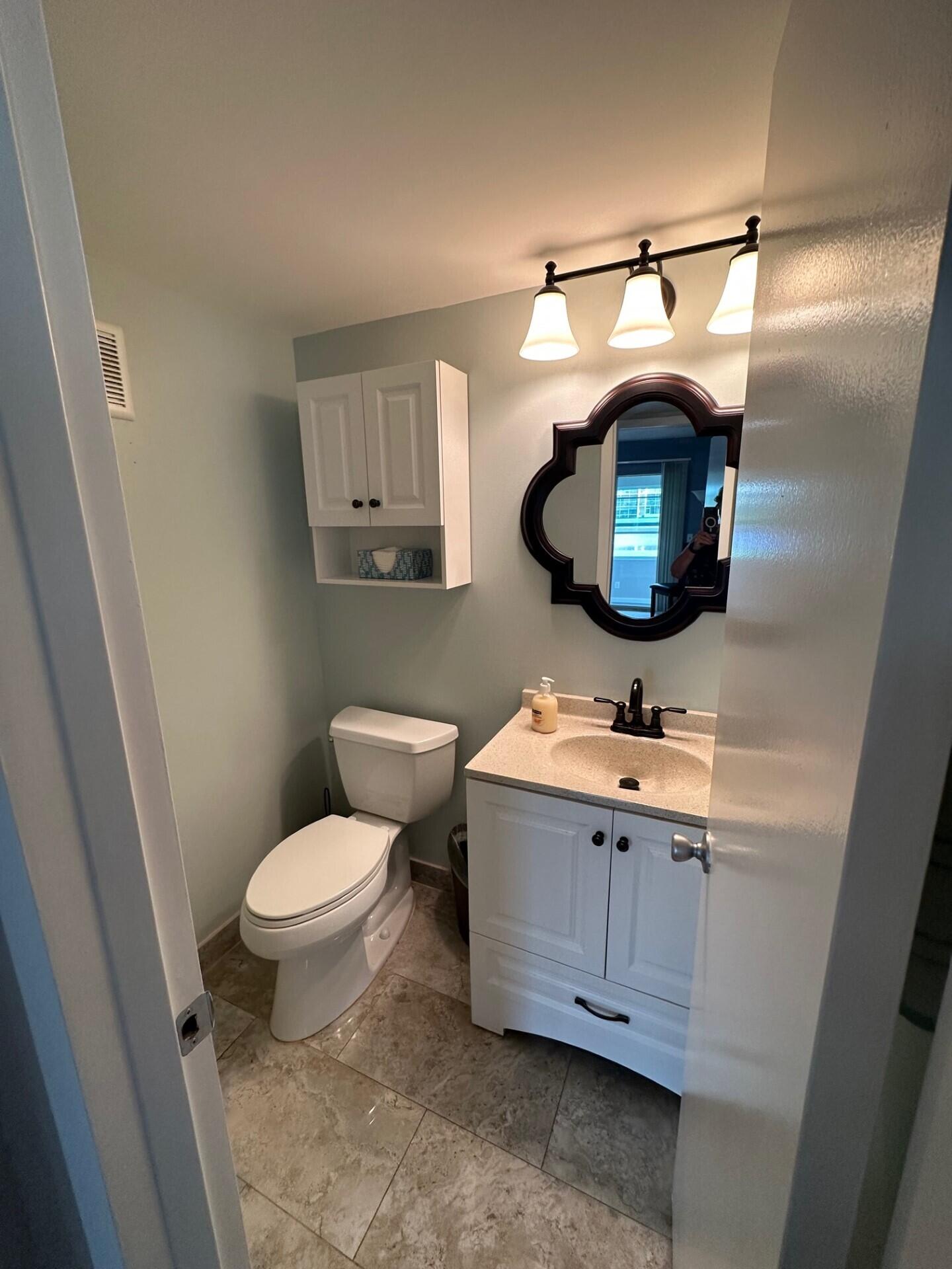 340 Mansfield Drive Boca Raton, FL 33434 - Photo 18 of 23 a bathroom with a toilet sink and mirror