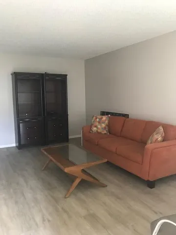 a living room with furniture and a air conditioner vent