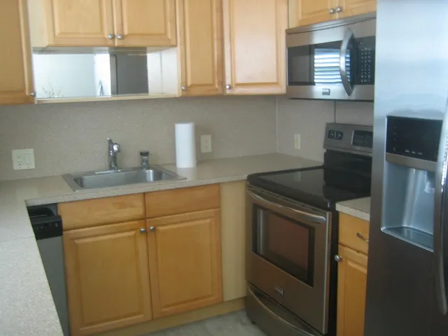 a kitchen with granite countertop cabinets stainless steel appliances and a sink
