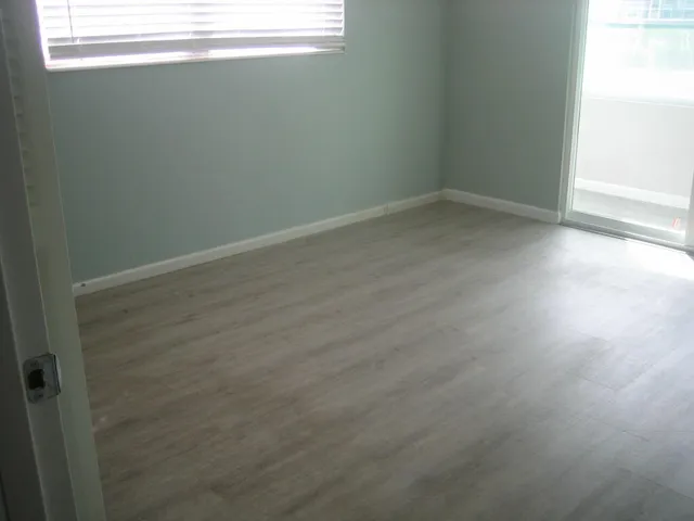 a view of a small space with wooden floor and a window
