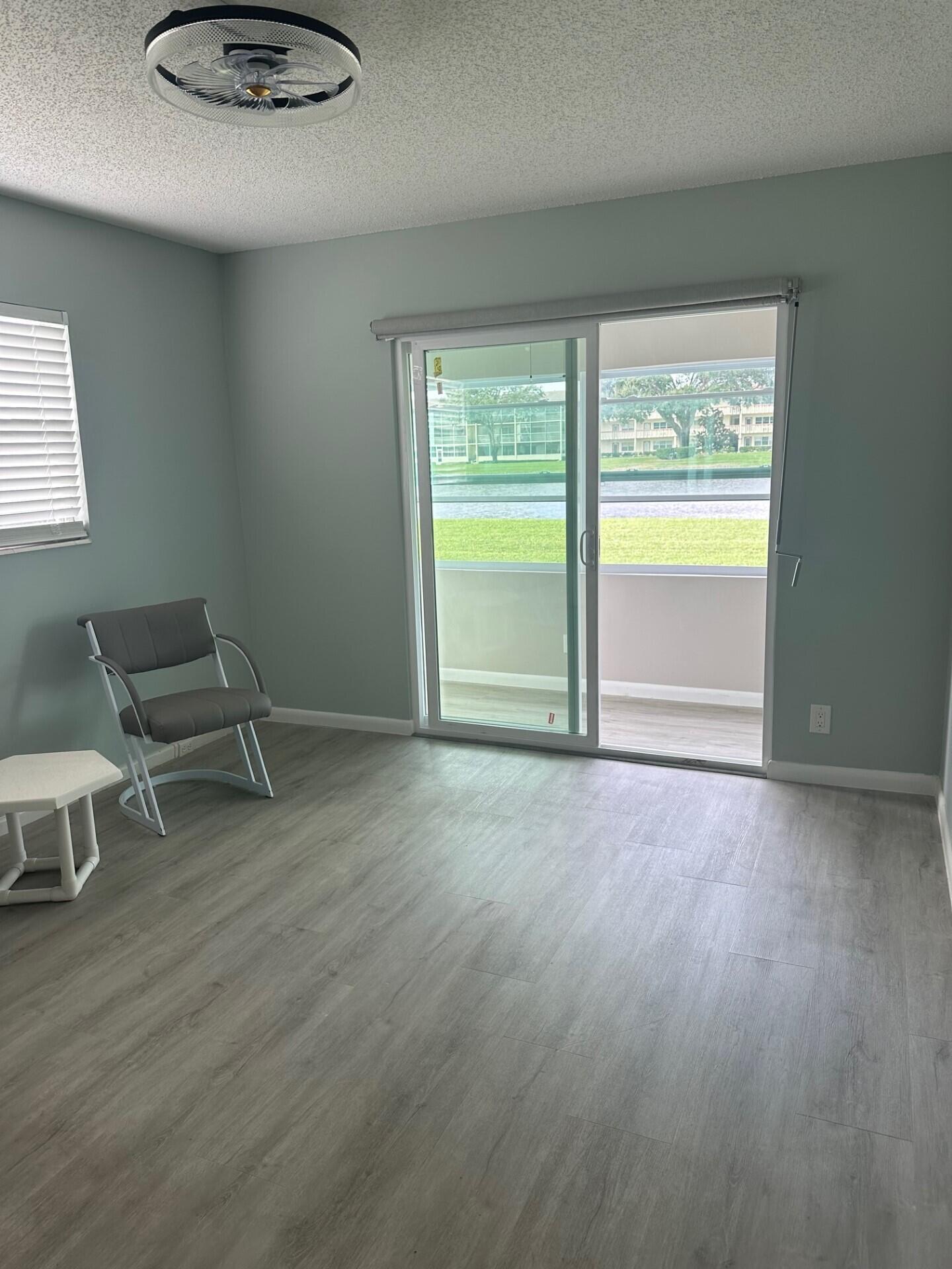 340 Mansfield Drive Boca Raton, FL 33434 - Photo 9 of 23 a view of an empty room with a window and wooden floor