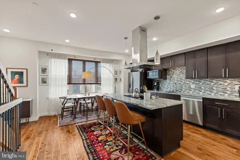 a kitchen with granite countertop a sink stove and cabinets
