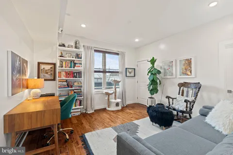 a living room with furniture and a dining table with bookshelf