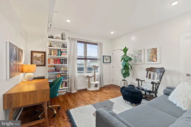 a living room with furniture and a dining table with bookshelf