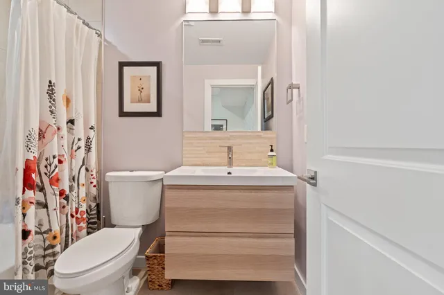 a bathroom with a toilet sink and mirror