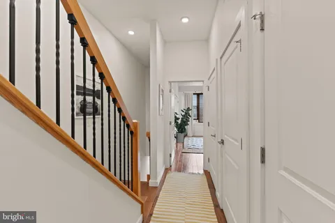 a view of a hallway with wooden floor and staircase
