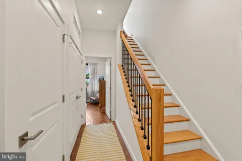 a view of a hallway with wooden floor and entryway
