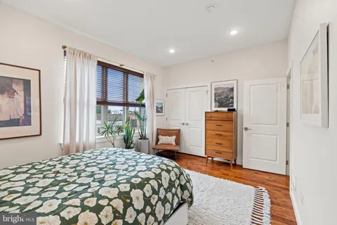 a bedroom with a bed and dresser with mirror