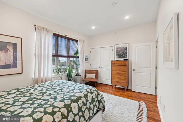 a bedroom with a bed and dresser with mirror