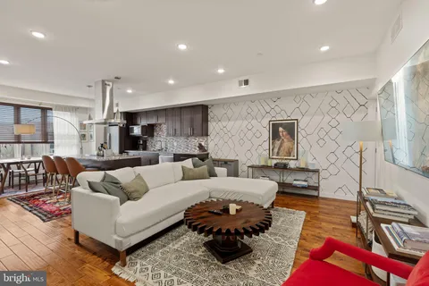 a living room with furniture hard wood floor and a rug