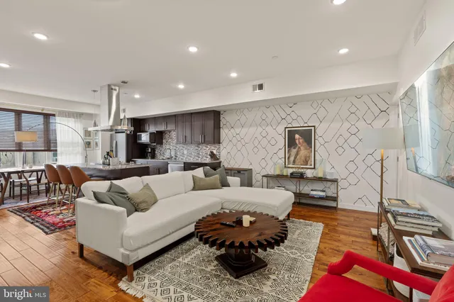 a living room with furniture hard wood floor and a rug