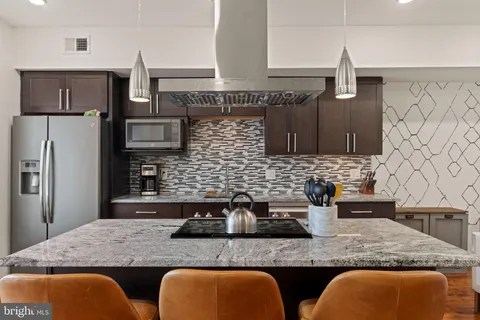 a kitchen with stainless steel appliances granite countertop a sink and a refrigerator