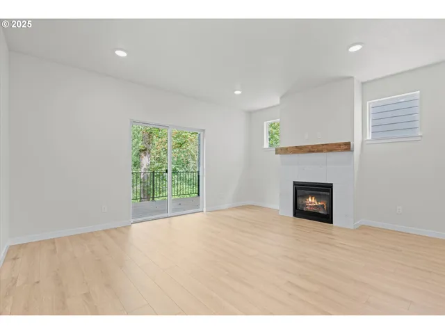 a view of an empty room with a fireplace and a window