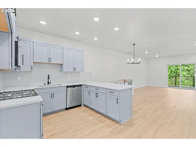 a kitchen with granite countertop a white stove top oven sink and cabinets