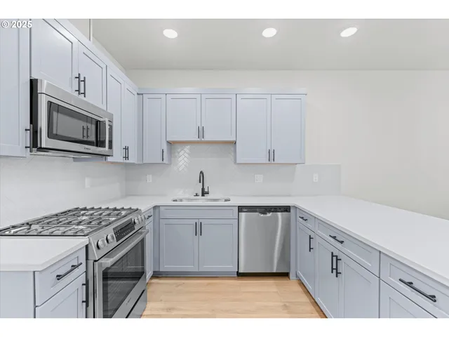 a kitchen with cabinets appliances a sink and a counter top